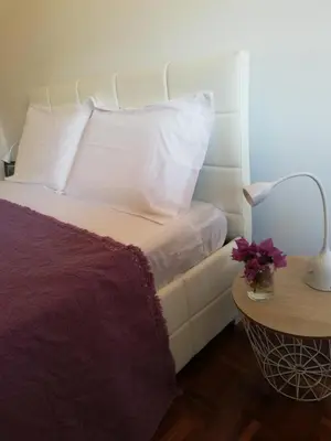 a bed with white pillows and a table with a lamp at FXapartment1 in Funchal