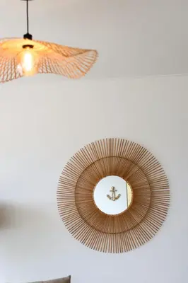 a mirror hanging on a wall with a light at Seashore Villa - Porto Santo in Porto Santo