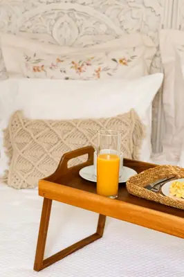 a tray with a glass of orange juice on a bed at Seashore Villa - Porto Santo in Porto Santo