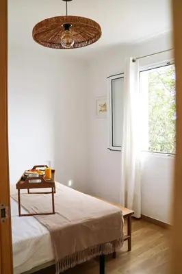 a bedroom with a bed with a table and a window at Seashore Villa - Porto Santo in Porto Santo