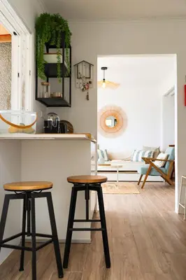 a living room with two stools in front of a counter at Seashore Villa - Porto Santo in Porto Santo