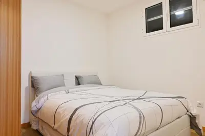 a white bedroom with a large bed with two windows at Casa Familia Pestana 1, a Home in Madeira in Seixal