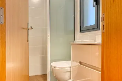 a bathroom with a toilet and a mirror at Casa Familia Pestana 1, a Home in Madeira in Seixal