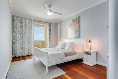 a white bedroom with a bed and a window at Apartament Falesia Paradise by Holiday Rental Madeira in Funchal
