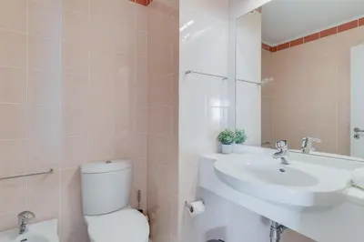 a white bathroom with a toilet and a sink at Apartament Falesia Paradise by Holiday Rental Madeira in Funchal