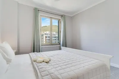 a white bedroom with a bed with a window at Apartament Falesia Paradise by Holiday Rental Madeira in Funchal