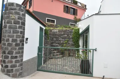 a house with a gate in front of a building at Vale dos Ilhéus in Machico