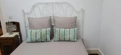 a bed with a white headboard and pillows at Refúgio do Santa in Calheta