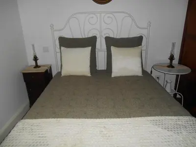 a bedroom with a large bed with two pillows at Refúgio do Santa in Calheta