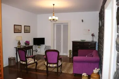 a living room with two purple chairs and a desk at Refúgio do Santa in Calheta