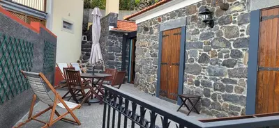 a balcony with chairs and a table and a building at Refúgio do Santa in Calheta