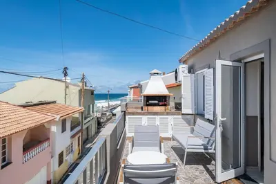 a balcony with chairs and a view of the ocean at Casa Tropicana in Paul do Mar