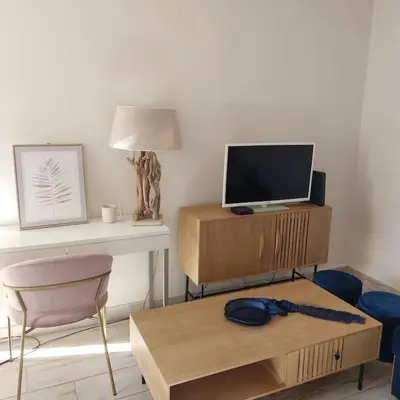 a living room with a desk with a television and a table at Casa Tropicana in Paul do Mar
