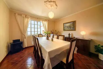 a dining room with a table and chairs and a window at Casa do Tornadouro by Mth in Ponta do Sol