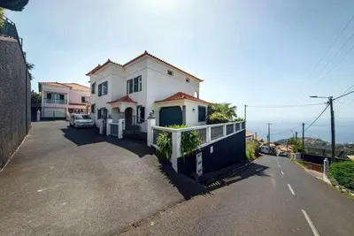 a large white house with a balcony on a street at Casa do Tornadouro by Mth in Ponta do Sol