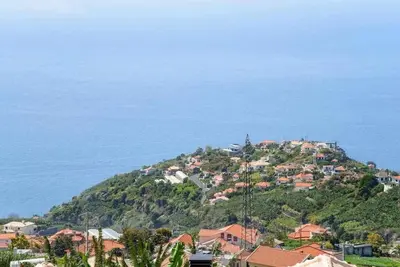 a town on top of a hill next to the ocean at Casa do Tornadouro by Mth in Ponta do Sol
