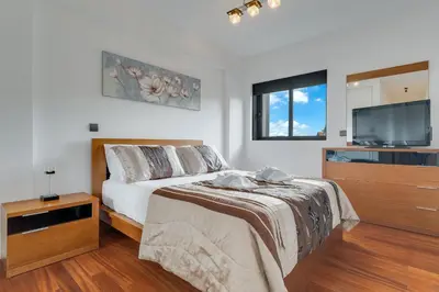 a bedroom with a bed and a flat screen tv at Ramos Apartment by Holiday Rental Madeira in Funchal