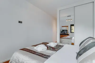 a bedroom with a white bed and a large mirror at Ramos Apartment by Holiday Rental Madeira in Funchal