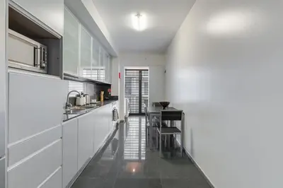 a kitchen with white cabinets and a table in it at Ramos Apartment by Holiday Rental Madeira in Funchal