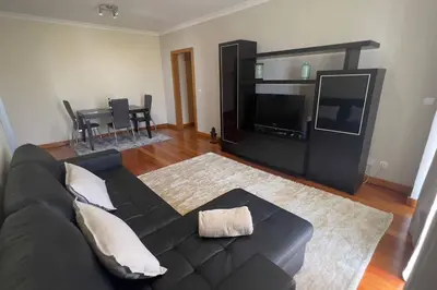 a living room with a black couch and a television at By the Sea V - Panoramic Pool Retreat in Funchal