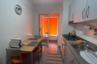 a small kitchen with a table and a sink at By the Sea V - Panoramic Pool Retreat in Funchal