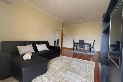 a living room with a black couch and a rug at By the Sea V - Panoramic Pool Retreat in Funchal