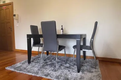 a black table with four chairs and a rug at By the Sea V - Panoramic Pool Retreat in Funchal