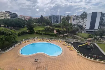 a large swimming pool in a city with chairs at By the Sea V - Panoramic Pool Retreat in Funchal