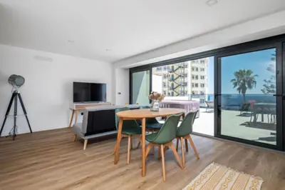 a living room with a table and green chairs at Over Sea in Funchal