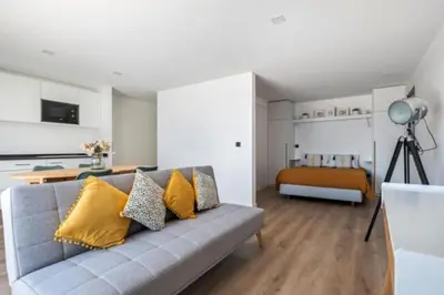 a living room with a gray couch with yellow pillows at Over Sea in Funchal