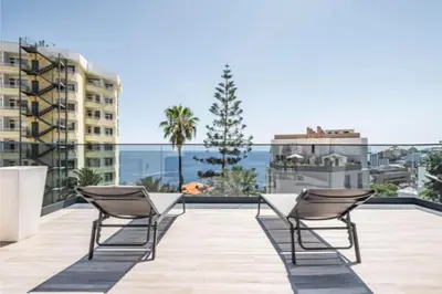 a patio with two chairs and a table on a roof at Over Sea in Funchal