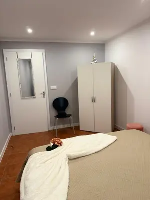 a bedroom with a bed and a chair and a cabinet at Gouveia Family Escape in Machico