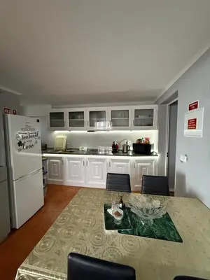 a kitchen with a table and a white refrigerator at Gouveia Family Escape in Machico