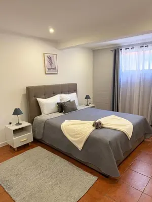 a bedroom with a large bed with two rugs at Gouveia Family Escape in Machico