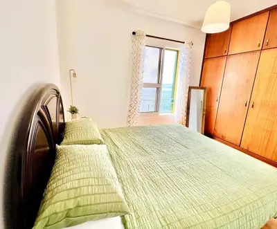 a bedroom with a bed with green sheets and a window at Apartment Paulo by Your Madeira Rentals in Ponta do Sol