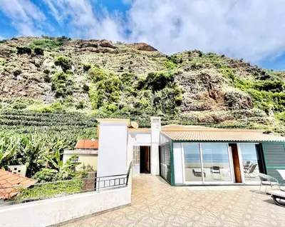 a house with a mountain in the background at Apartment Paulo by Your Madeira Rentals in Ponta do Sol