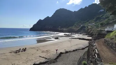 a beach with people on the sand and the ocean at Casa da Ponta Negra in Vila do Porto