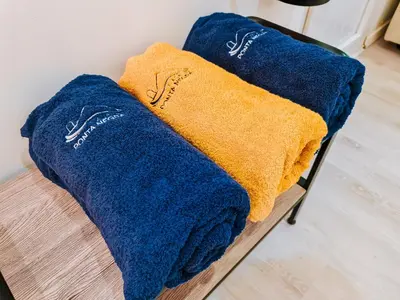 two blue and yellow towels sitting on a bench at Casa da Ponta Negra in Vila do Porto