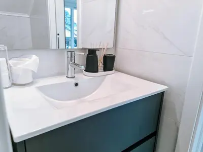 a bathroom with a white sink and a mirror at Casa da Ponta Negra in Vila do Porto
