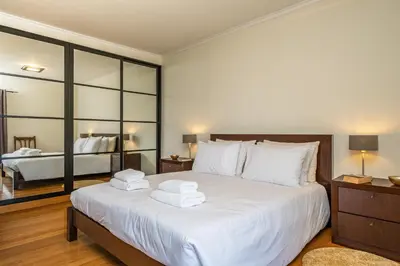a bedroom with a large white bed with towels on it at Casa da Palmeira in Funchal