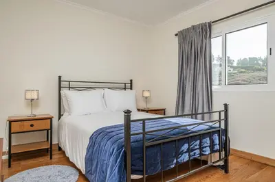 a bedroom with a bed and a window at Casa da Palmeira in Funchal