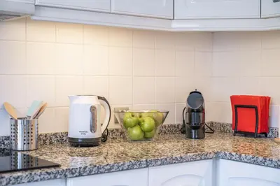 a kitchen counter with a coffee maker and apples on it at Casa da Palmeira in Funchal