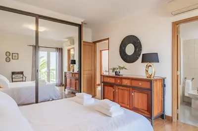 a bedroom with two beds and a mirror at Casa da Palmeira in Funchal