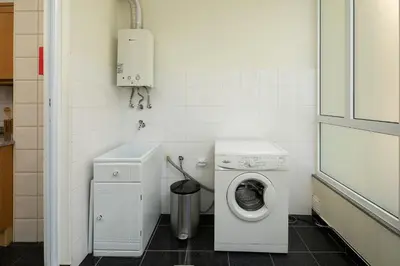 a small bathroom with a washing machine and a washer at Apartamento Vale e Mar in Calheta