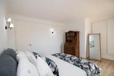 a bedroom with a white bed and a mirror at Villa Ílios - Porto de Mós, Lagos in Lagos