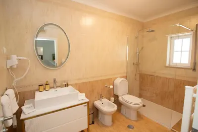 a bathroom with a sink toilet and a mirror at Villa Ílios - Porto de Mós, Lagos in Lagos