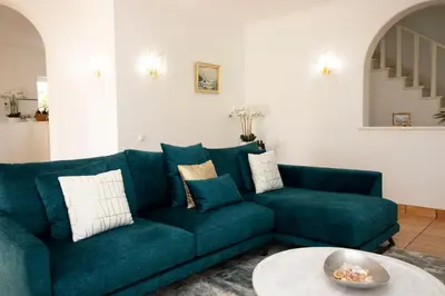 a living room with a blue couch and a table at Villa Ílios - Porto de Mós, Lagos in Lagos