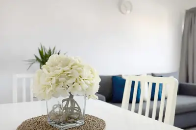 a vase filled with white flowers sitting on a table at Victoria's House in Sagres