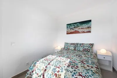 a bedroom with a bed and a painting on the wall at Victoria's House in Sagres