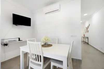 a white dining room with a white table and chairs at Victoria's House in Sagres